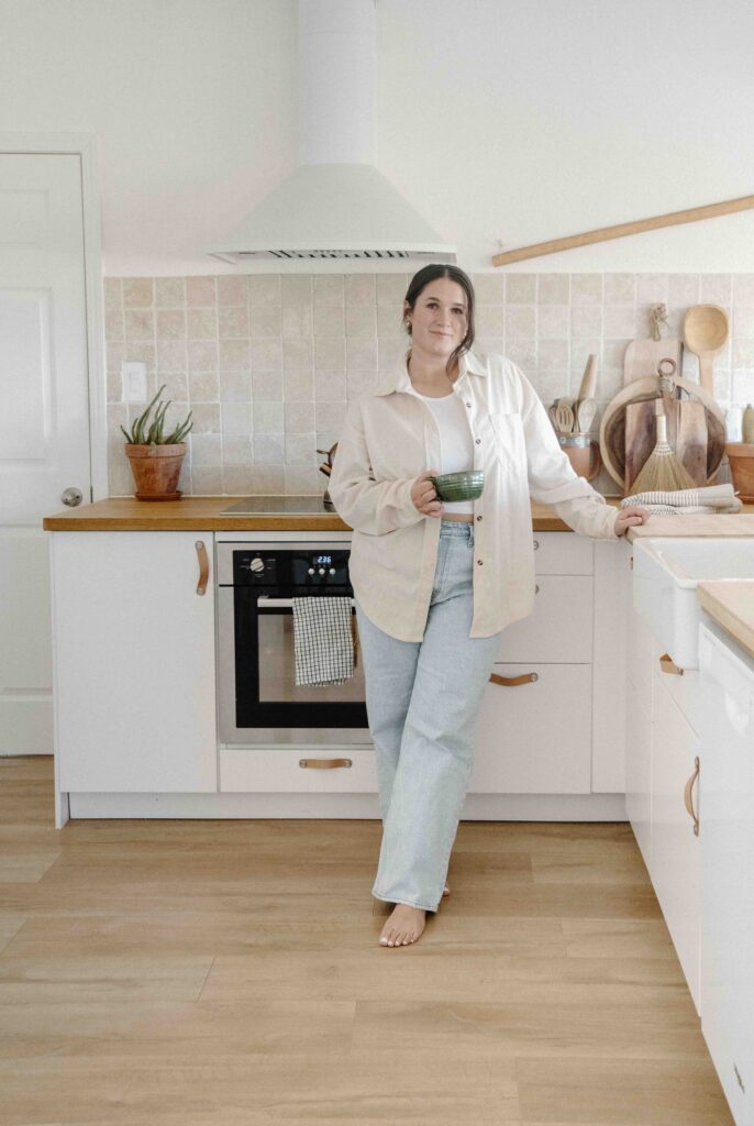 woman leaning on counter in kichen in a neutral and casual personal branding photoshoot outfit